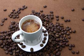 Coffee bean in white cup with  on wooden board