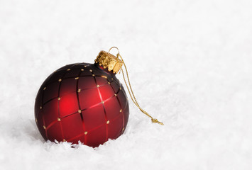 Red Christmas ball ornament on snow background