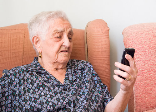 Elderly Woman Looking At A Smartphone With Confused Expression