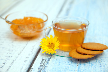 The cap of tea with coocies, marguerite flower and orange jam