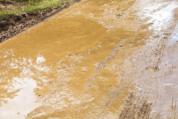 mud and puddle in rut of dirt ground road
