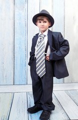 the boy stands in an elegant suit - 57110569