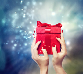 Red present box held up by in a woman's hands