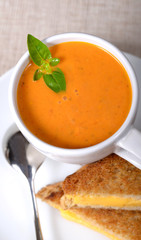 Delicious bowl of tomato soup with grilled cheese sandwich