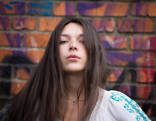 Naklejka premium Portrait of a girl posing over brick wall.