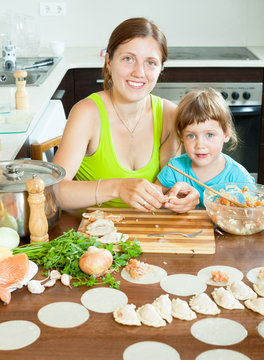 mother with daughter making fish dumplings in a home large kitch