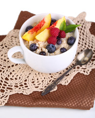 Oatmeal in cup with berries on napkins isolated on white