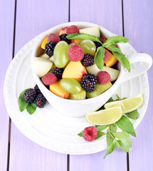 Fruit salad in cup on wooden table