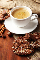 Cup of tasty coffee with tasty cookies, on wooden background