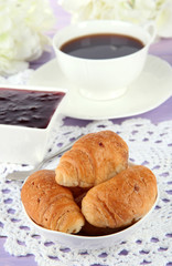 Tasty croissants and cup of coffee on table close-up