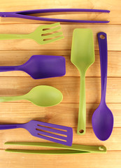 Plastic kitchen utensils on wooden background