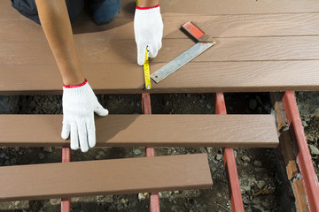 Worker installing  wood floor for patio