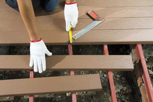 Worker Installing  Wood Floor For Patio