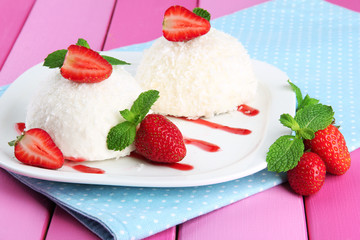 Delicious coconut cakes on plate on table close-up
