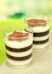 Tasty jelly coffee with milk on table on light background