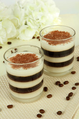 Tasty jelly coffee with milk on table on light background