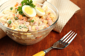 Russian traditional salad Olivier,  on wooden  background