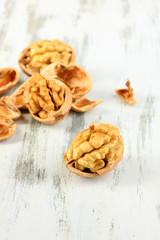 Broken walnuts on wooden table close-up