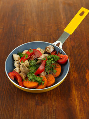 Sliced fresh vegetables in pan on wooden table close-up