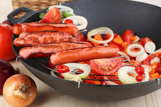 Delicious sausages with vegetables in wok