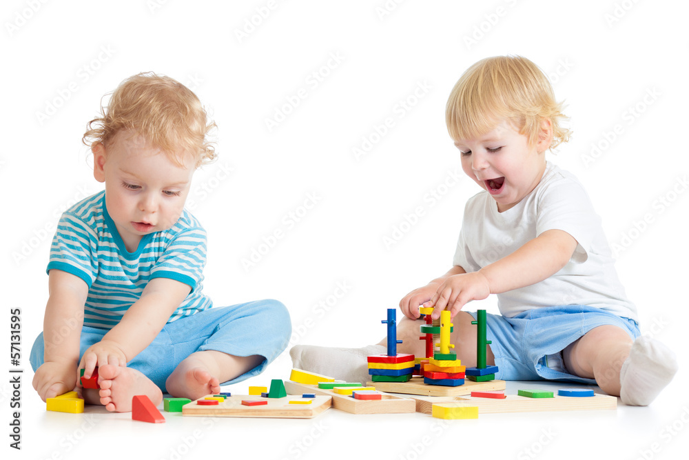 Fototapete Two kids playing wooden toys together sitting
