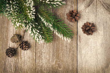 Christmas vintage wooden background with fir branches and cones