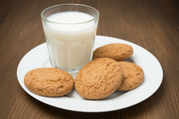 glass of milk and oat cookies on a plate, horizontal