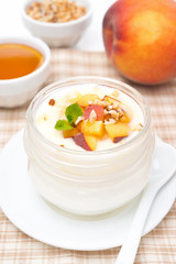 homemade yogurt with honey, peaches and nuts, vertical