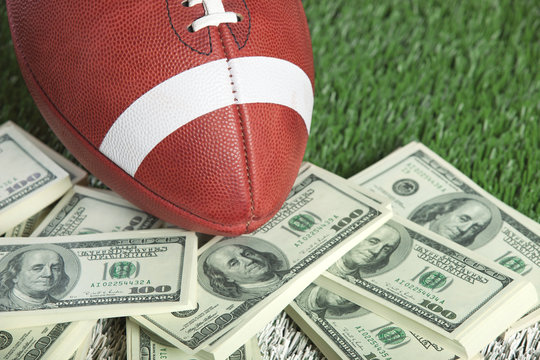 College style football on field with a pile of money