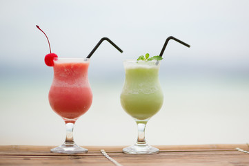 Two fresh fruit juices on a tropical beach
