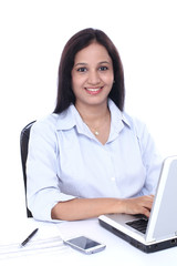 Smiling young business woman working with laptop