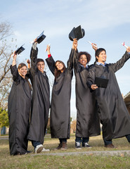 Students With Diplomas Celebrating Success On Graduation Day At