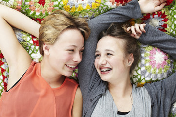 Two sisters lying on a blanket