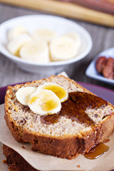 Slice of banana cake with pecans and maple syrup