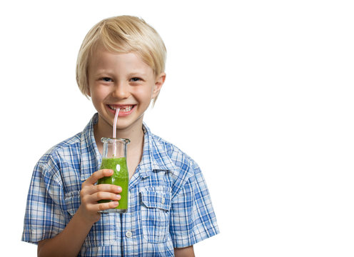 Cute young boy drinking green smoothie