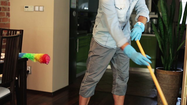 Man sweeping the floor at home