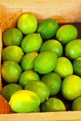 Fresh limes in a wooden crate.