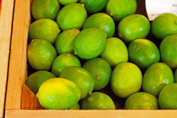Fresh limes in a wooden crate.