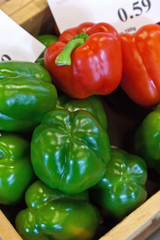 Green and red peppers in a wooden crate.
