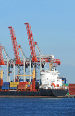 Fototapeta premium Container stack and cargo ship under crane bridge