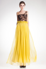 beautiful woman posing in long yellow dress with black lace - 57162596