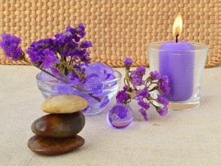 Obraz na płótnie Canvas Candle and purple flowers