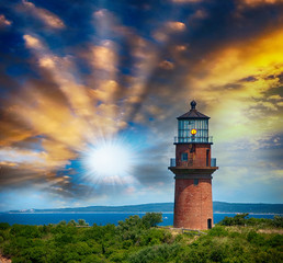 Lighthouse on a beautiful island. Sunset view with trees and sea