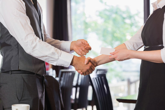 Business team shaking hands and swapping card
