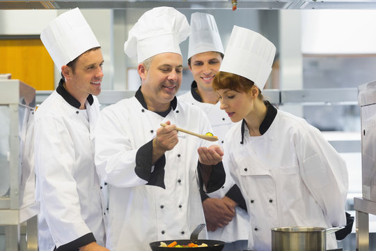 Senior chef showing food to his colleagues