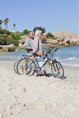 Senior couple with their bikes on the beach