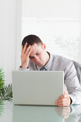 Close up of disappointed businessman looking at his laptop