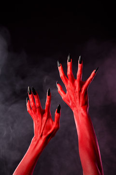 Red devil hands with black sharp nails, extreme body-art