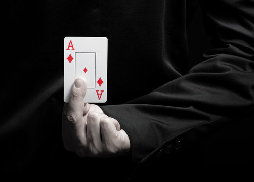 Businessman showing ace card behind his back