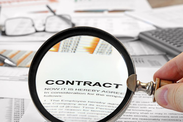 Magnifying Glass Over Contract Papers